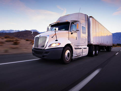 Semi truck driving down highway in the evening