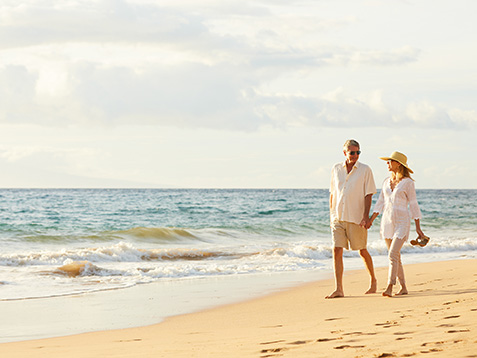 Happy Romantic Middle Aged Couple Enjoying Beautiful Sunset Walk on the Beach. Travel Vacation Retirement Lifestyle Concept