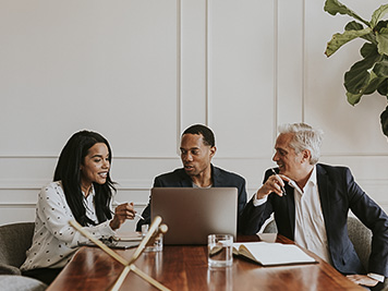 Happy business people using a laptop