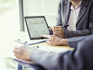 Business people analyzing investment charts with teblet in meeting room, Accounting concept, soft focus, vintage tone